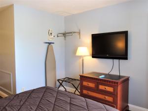 格罗顿温莎汽车旅馆的一间卧室配有一张床和一台平面电视