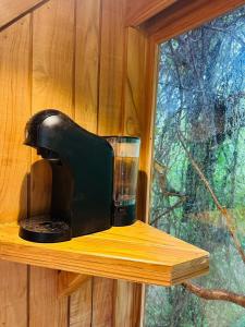 GuatemalaTamarindo Pura Selva Eco Tree House的坐在窗户旁的木架上的咖啡壶