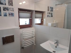 弗瓦迪斯瓦沃沃Domki Oaza Spokoju的白色的浴室设有水槽和镜子