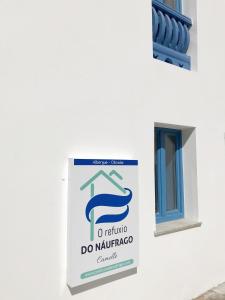 CamelleO Refuxio do Náufrago的建筑一侧的标志,带有窗户