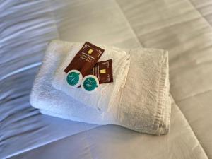拉塞雷纳Hotel Chagual的床上的白色毛巾、巧克力和两张贴纸