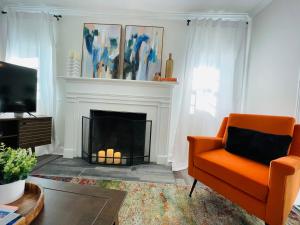 伯明翰Large Renovated Cottage on East Lake Park的客厅配有橙色椅子和壁炉