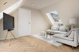 卑尔根Dinbnb Apartments I Mid-City Luxury with Mini Balcony and Smart TV & Sound System的带沙发和电视的客厅