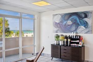 巴拿马城海滩Holiday Terrace Beachfront Hotel, a By The Sea Resort的客房设有带葡萄酒瓶的桌子和窗户。