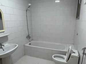利雅德Hakimdom Hostel的带浴缸、卫生间和盥洗盆的浴室