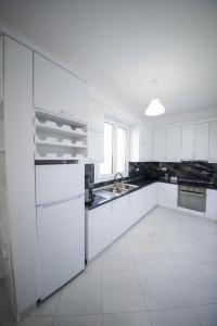 迪夫亚卡Vila Kokoneshi的白色的厨房配有白色橱柜和水槽