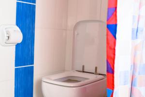 达累斯萨拉姆Taste of Mexico Hostel的浴室设有卫生间和色彩缤纷的浴帘