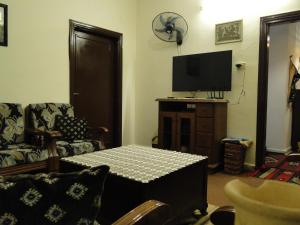 乌姆盖斯( b&b ) Gadara rent room的客厅配有桌子和电视