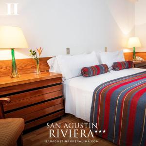 利马圣奥古斯丁海滨酒店的一间卧室配有一张床和一张带台灯的书桌
