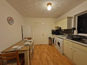 KentSwanley Guest House的厨房配有桌子和炉灶。 顶部烤箱