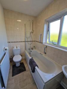 KentSwanley Guest House的带浴缸、卫生间和盥洗盆的浴室