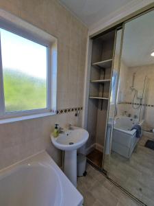 KentSwanley Guest House的带浴缸、水槽和淋浴的浴室