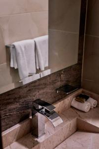瓦哈卡市Hotel Casa Cantera的浴室配有盥洗盆、镜子和毛巾
