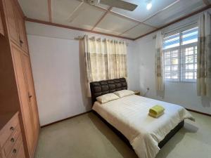 瓜拉丁加奴Spacious Home in Kuala Terengganu的一间卧室配有一张带黑色床头板的床和窗户