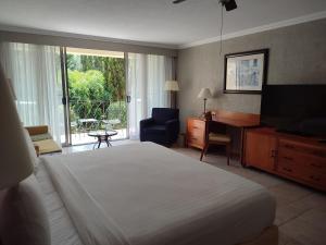 伊斯塔潘德拉萨尔Ixtapan de la Sal Marriott Hotel & Spa的酒店客房配有一张床、一张书桌和一台电视。