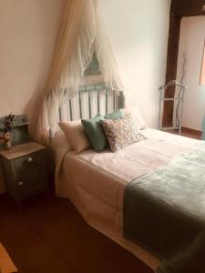 QuintanaLas maletas del pasiego的一间卧室配有一张带天蓬和枕头的床