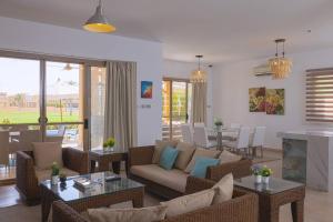 艾因苏赫纳Safty Palm Oasis Private Pool & Beach Access的客厅配有沙发、椅子和桌子