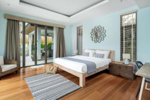 邦涛海滩Tropical villa within 5 minutes walk to Bangtao Beach的一间带大床的卧室和一间客厅