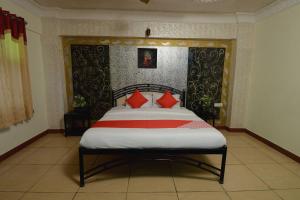 焦特布尔OYO Flagship Ranibagh Palace的一间卧室配有一张带红色枕头的大床