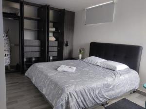 TocancipáTOCANCIPÁ, Increíble, Hermoso y Moderno APARTAMENTO COMPLETO!的一间卧室配有一张大床和黑色床头板