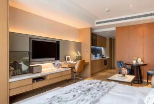 上海自在居珀瑞公寓(国家会展中心店)的一间卧室配有一张床和一张书桌及电视