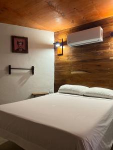 图卢姆Malakai Hostel的卧室配有白色的床和风扇