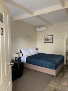 凯恩顿Central Highlands Motor Inn的一间卧室配有一张带蓝色棉被的床