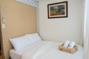 马尼拉QS Realty的一间小卧室,配有白色的床和一张照片
