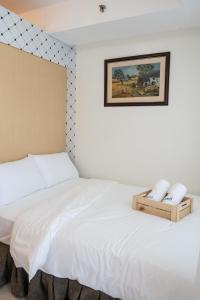 马尼拉QS Realty的卧室配有白色的床,墙上挂着一幅画
