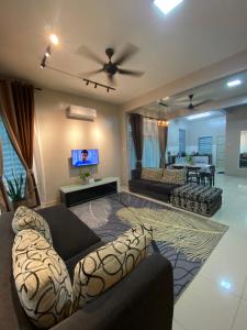 甲抛峇底Homestay Aalaiya Bertam Kepala Batas - Fully Aircond的客厅配有两张沙发和一台电视机