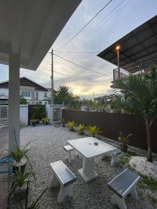 甲抛峇底Homestay Aalaiya Bertam Kepala Batas - Fully Aircond的庭院配有白色桌子和2个长凳