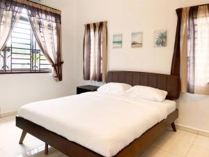 峇株巴辖Nestle Homestay@Batu Pahat的卧室配有一张带白色床单和窗户的大床。