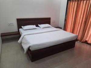 马尔万Raapan Beach Resort的一间卧室配有两张床和橙色窗帘