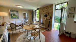 博讷MonCoeur, maison et jardin à 700 m des Hospices de Beaune的厨房以及带桌椅的起居室。