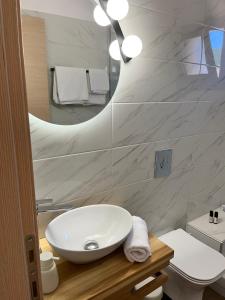 瓦西利基阿克罗伊亚利度假公寓的浴室设有白色水槽和镜子