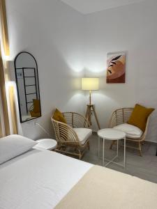 瓦西利基阿克罗伊亚利度假公寓的一间卧室配有床、椅子和一盏灯
