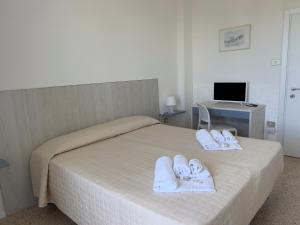 卡斯特尔萨多卡斯泰尔萨多杜马斯海滩酒店的一间卧室配有一张带毛巾的床和一张书桌