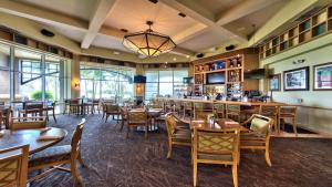 那不勒斯Catina Golf Condo at the Lely Resort的一间带桌椅的餐厅和一间酒吧