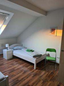 克雷费尔德Appartement Krefeld-City的一间卧室配有一张床和一把绿色椅子