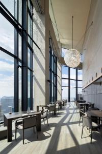 东京BELLUSTAR TOKYO, A Pan Pacific Hotel的餐厅设有桌椅和大窗户。