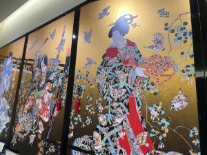 泉佐野Odysis Suites Osaka Airport Hotel的连衣裙上的一幅画女人的墙