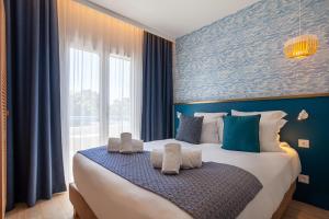 勒拉旺杜Hôtel La Piscine的一间卧室配有一张带蓝色墙壁的大床