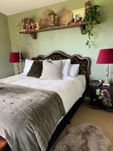 拉格伦Fridas Accommodation的卧室配有一张带白色床单和枕头的大床。