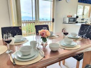 MoonahSpacious Home in West Moonah, Hobart的餐桌,配有盘子和酒杯