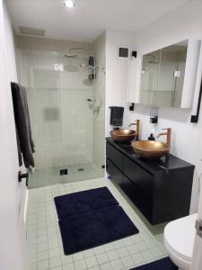 悉尼Bondi Junction Beauty的一间带两个盥洗盆和淋浴的浴室