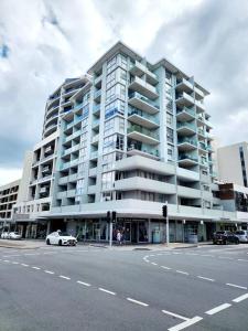 悉尼Bondi Junction Beauty的一座大型公寓楼,前面设有停车场