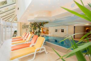 埃普芬多夫Berghof-Chalet的一个带游泳池和一束椅子的房间