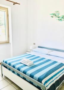 康培斯Appartamenti vicini al mare a Giglio campese的白色的客房配有蓝色和白色床单