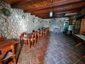 茨里克韦尼察巴尔利卡住宿加早餐旅馆的餐厅设有石墙,配有木桌和椅子