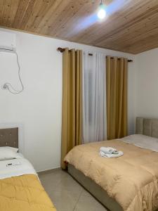KomanLugina e Komanit的一间卧室设有两张床,窗户配有窗帘